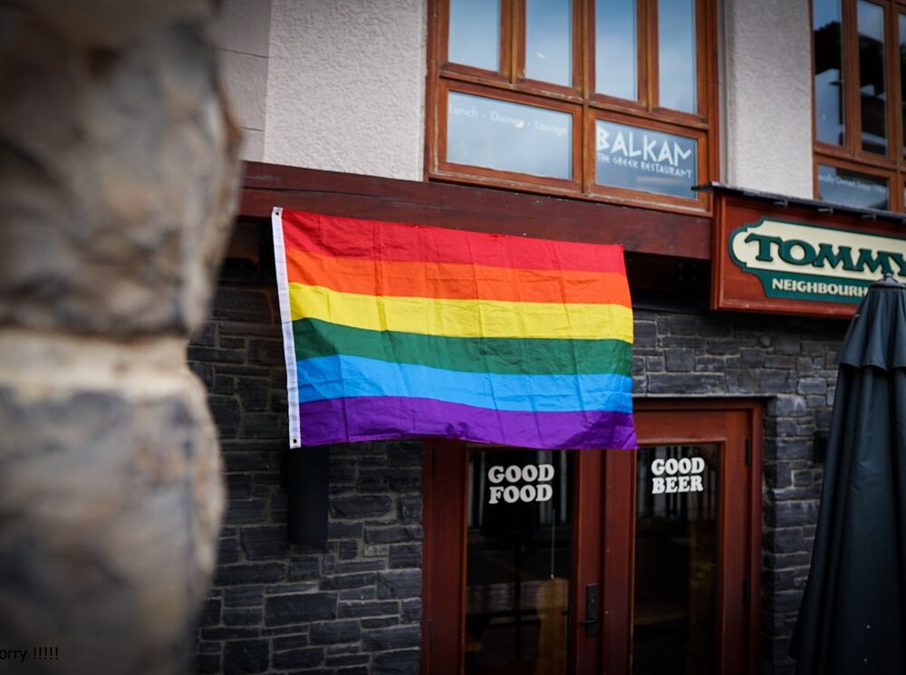 Banff Pride flag in front of Tommy's Neighborhood Pub.